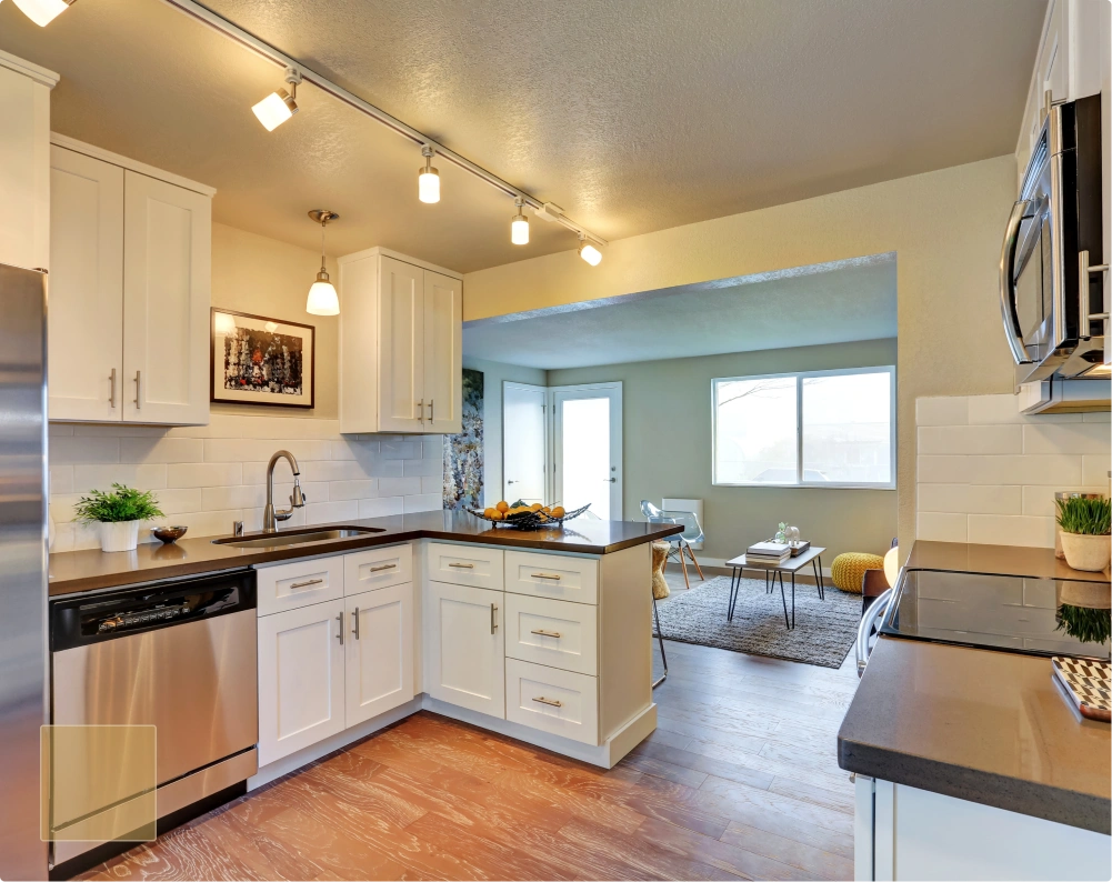 Modern kitchen remodel with white shaker-style cabinets, stainless steel appliances, dark quartz countertops, and a white subway tile backsplash.