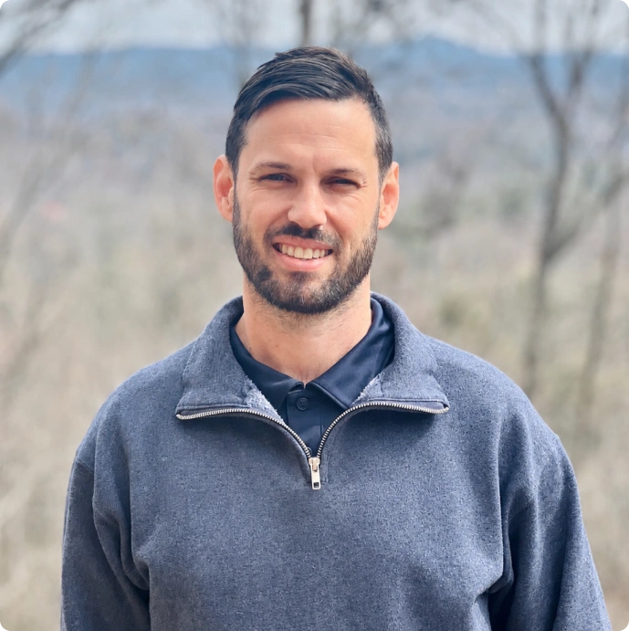 David Heidrick smiling outdoors in a sweater.