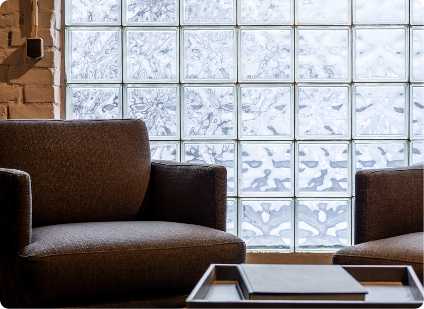 Two chairs by a glass block window